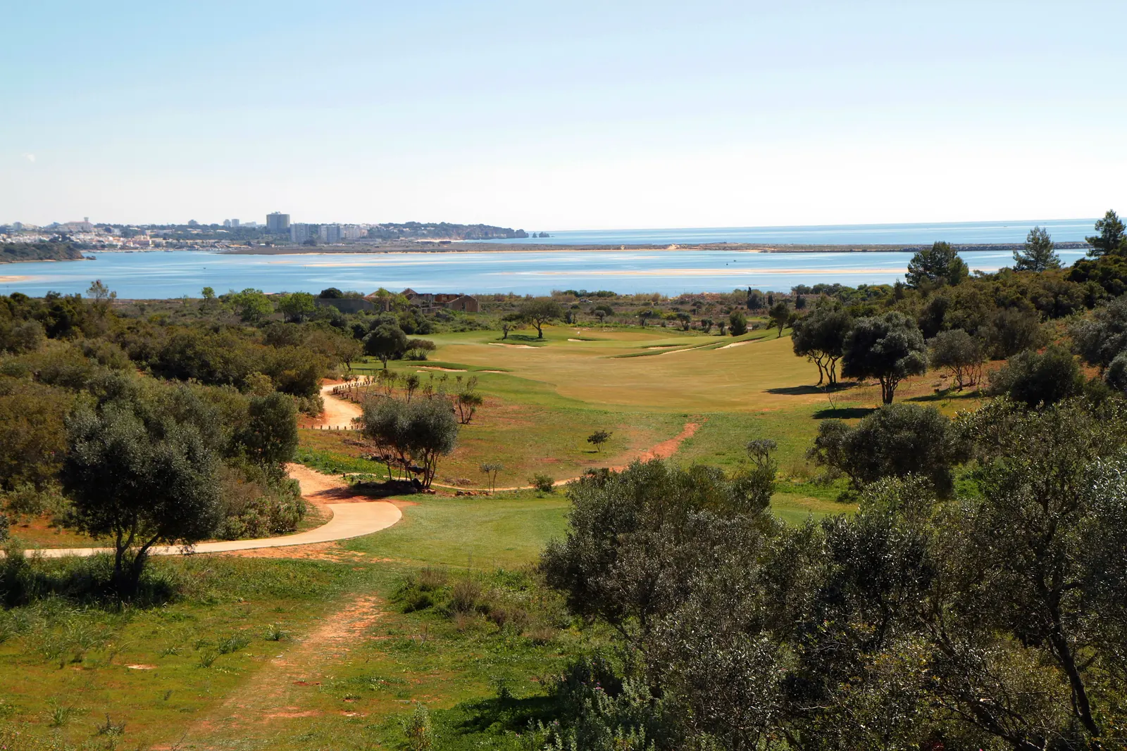 Fairways e oliveiras sobre uma baía no barlavento